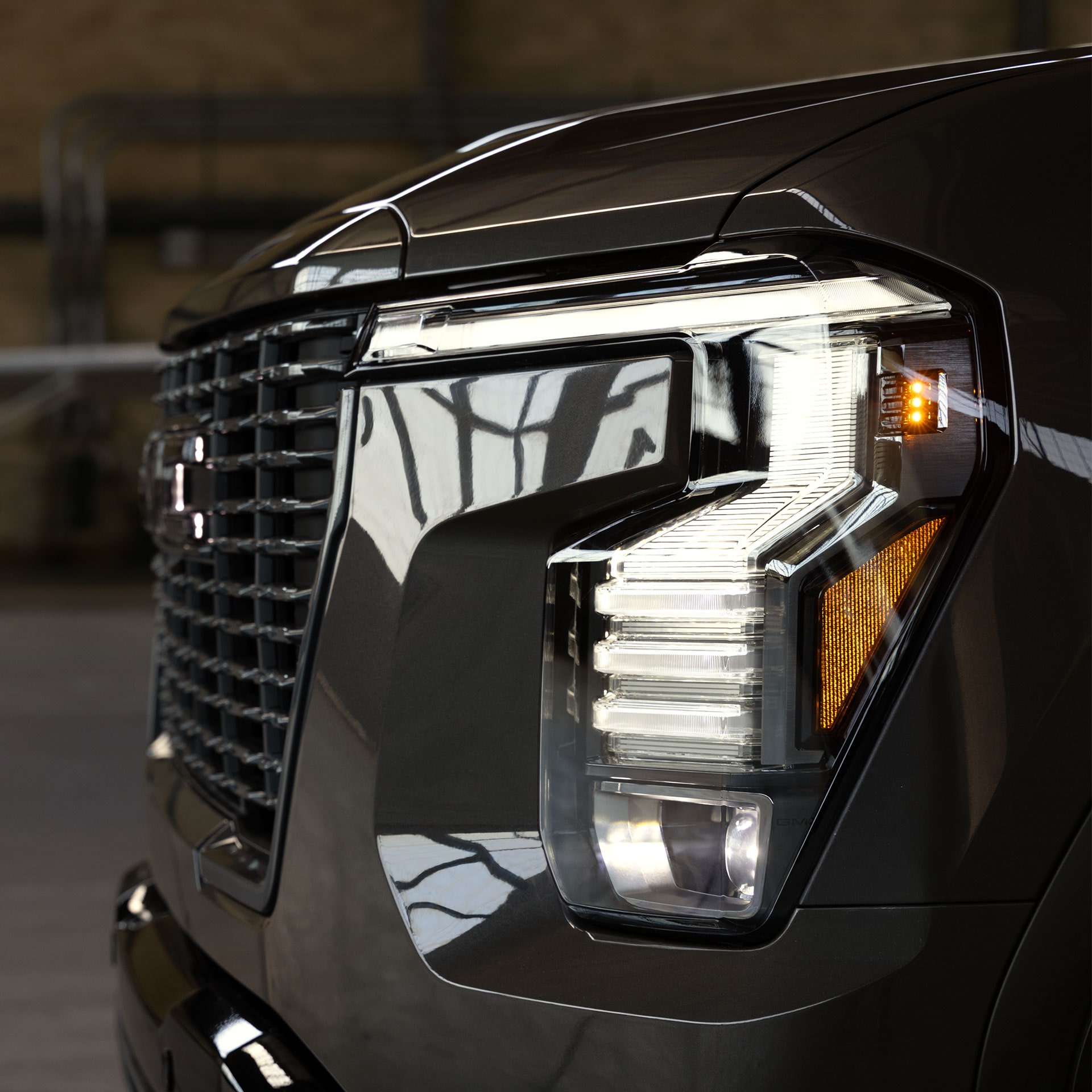 Close-Up View of the Modern LED Headlight and Grille on a Dark Gray 2027 GMC Sierra 1500