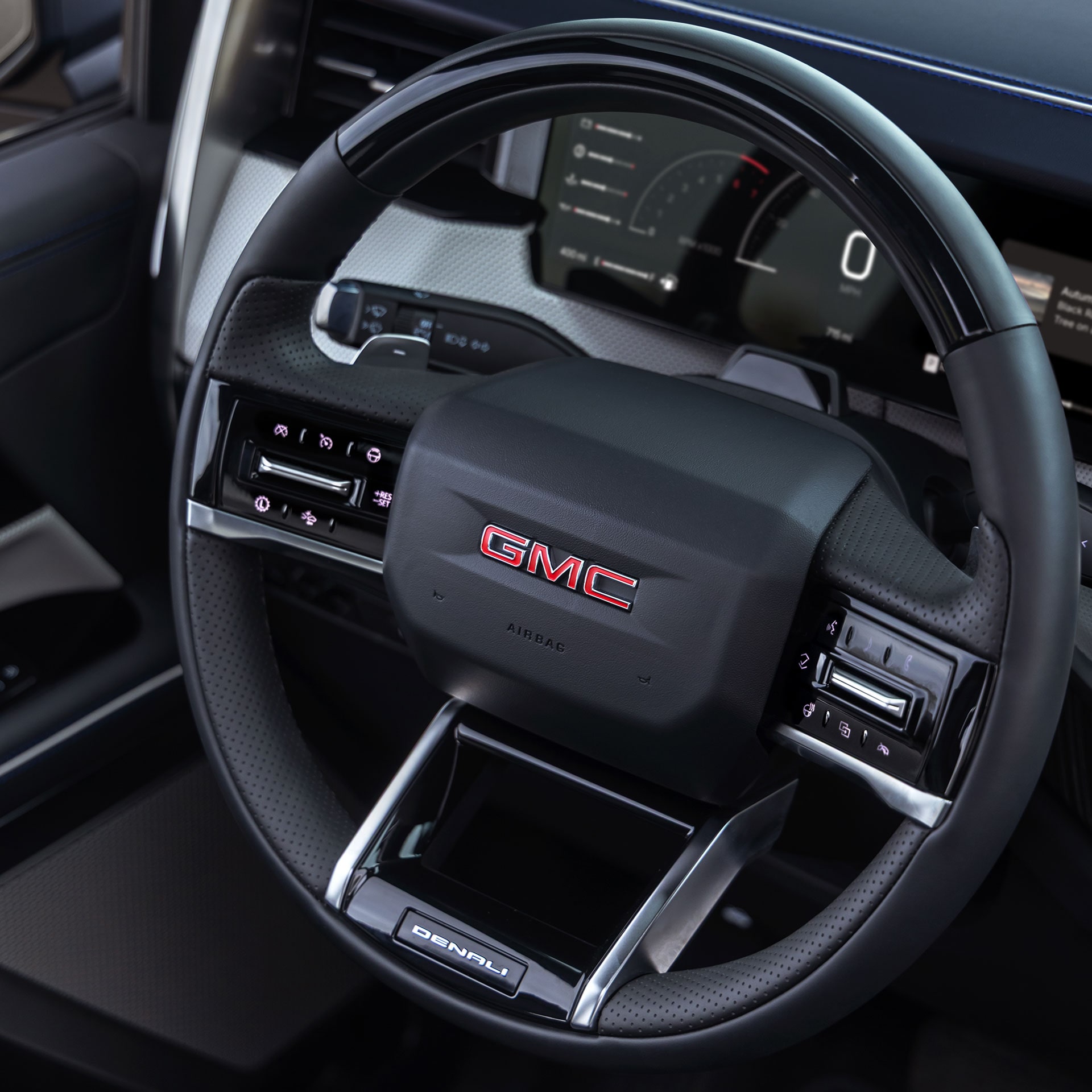 A Close Up View of the GMC Denali Steering Wheel With the Red GMC Logo Prominently Displayed