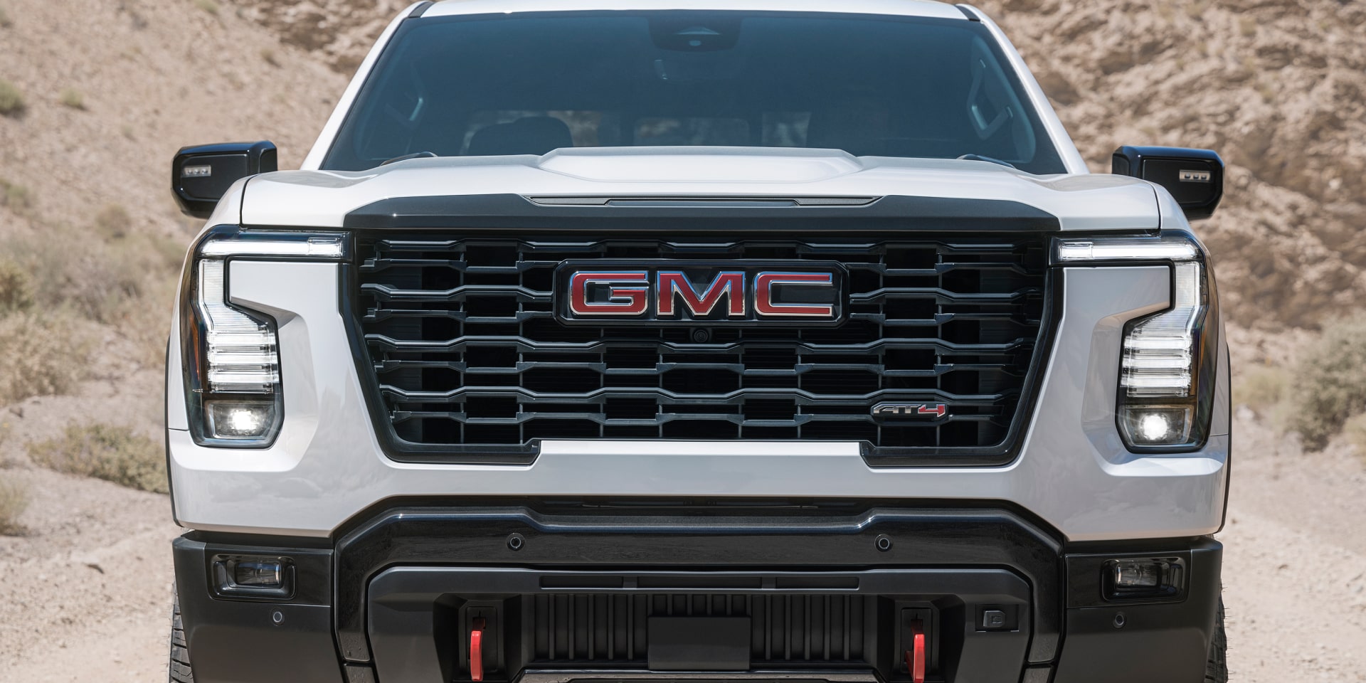 Front of a white 2027 GMC Sierra 1500 AT4 on a desert trail