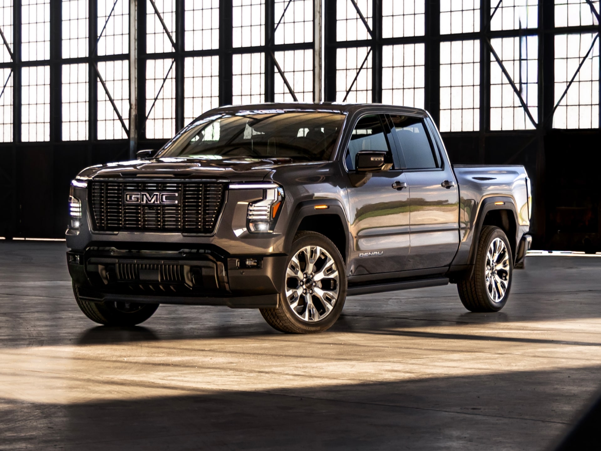 GMC Sierra 1500 Denali Ultimate pickup parked in a hangar; current 2027 model shown, while NHTSA's review covers 2022-2024 trucks