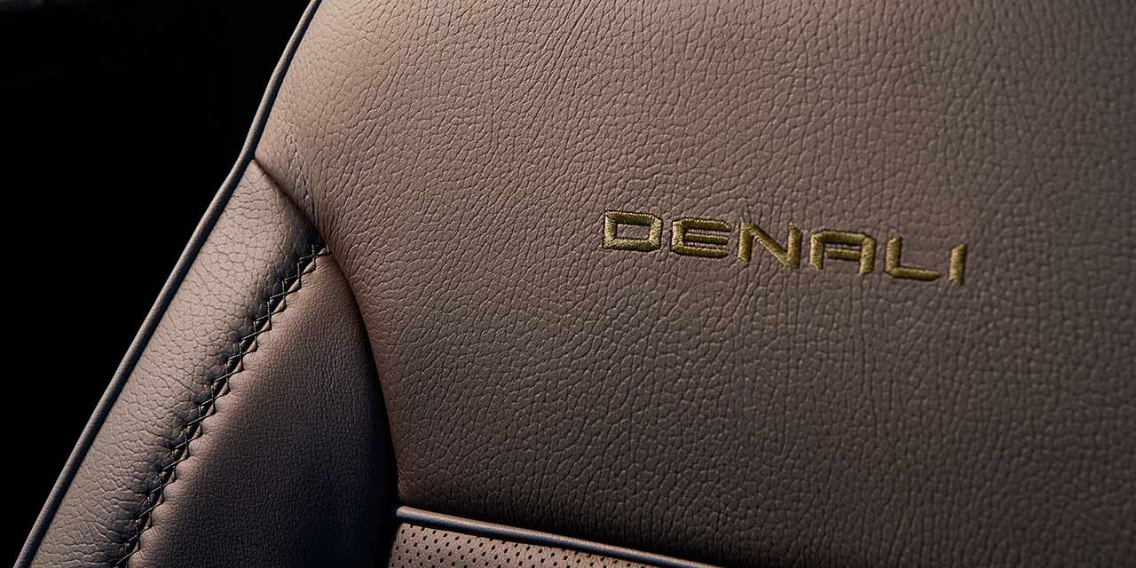 The Denali Trim Name Embroidered in Gold on a Brown Leather Seat of a GMC Sierra HD