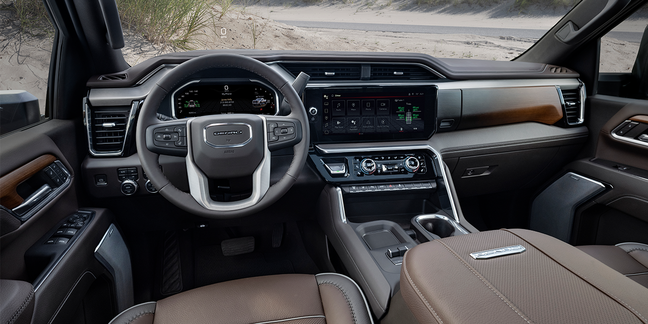 The Full Interior of a 2027 GMC Sierra HD with Brown Leather Seats and a View of a Desert