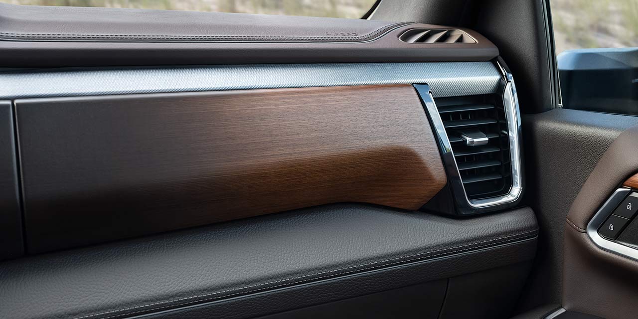 A Close-Up of the Brown Wood Trim and Air Vent on the Dashboard of a GMC Sierra HD