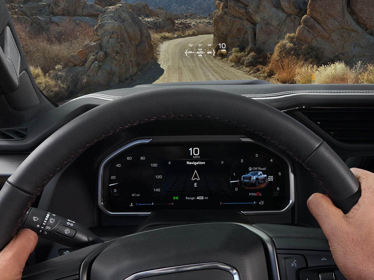 An Interior View of the 2027 GMC Sierra HD Dashboard with Hands on the Steering Wheel and a Digital Instrument Cluster Showing Navigation