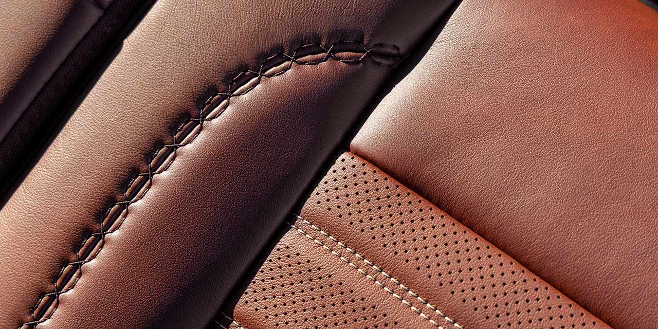 A Close-Up of the Brown Leather Upholstery with Stitching and Perforations in a GMC Sierra HD Seat