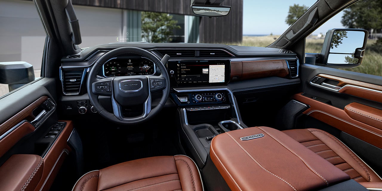 The Interior of a 2027 GMC Sierra HD with Brown Leather Seats and a Modern House in the Background