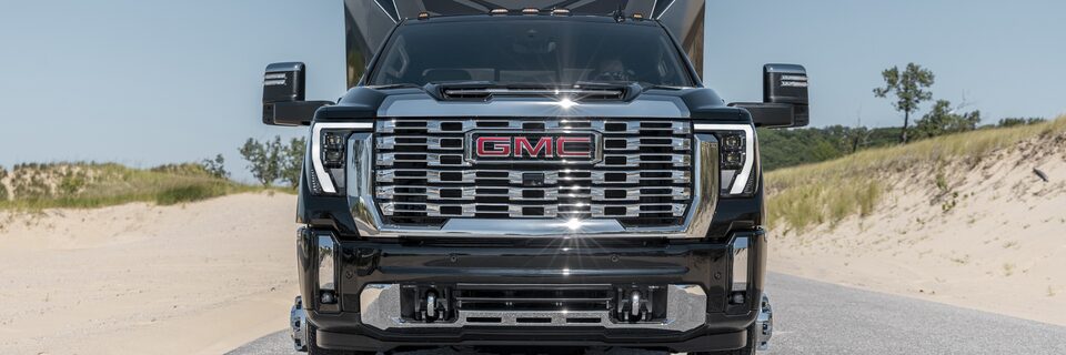 The Powerful 2024 GMC Sierra HD Towing a Trailer On Road by the Beach