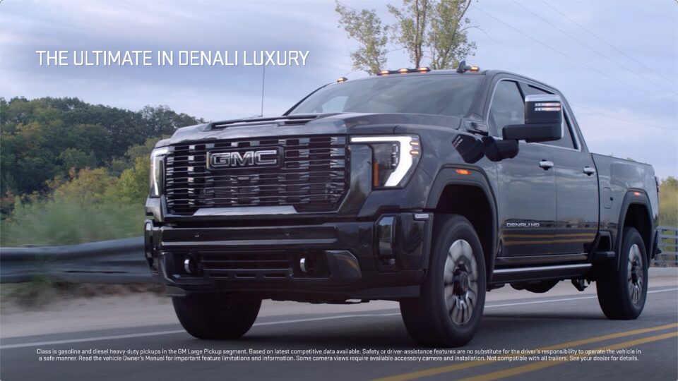 The GMC Sierra HD Driving on-road with text saying "The Ultimate In Denali Luxury"