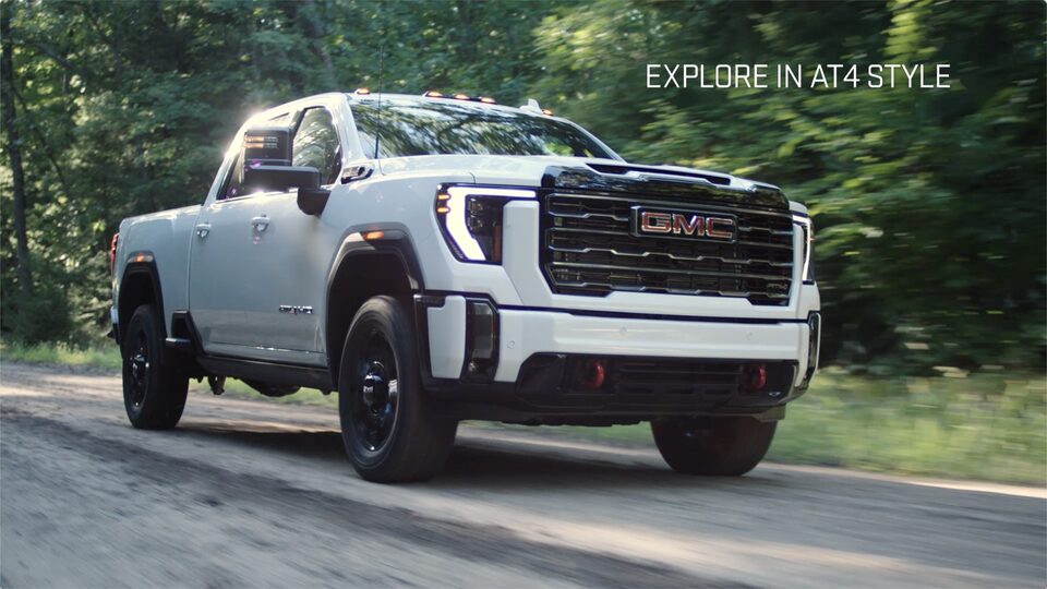 The White GMC Sierra HD With Text saying "Explore In AT4 Style"