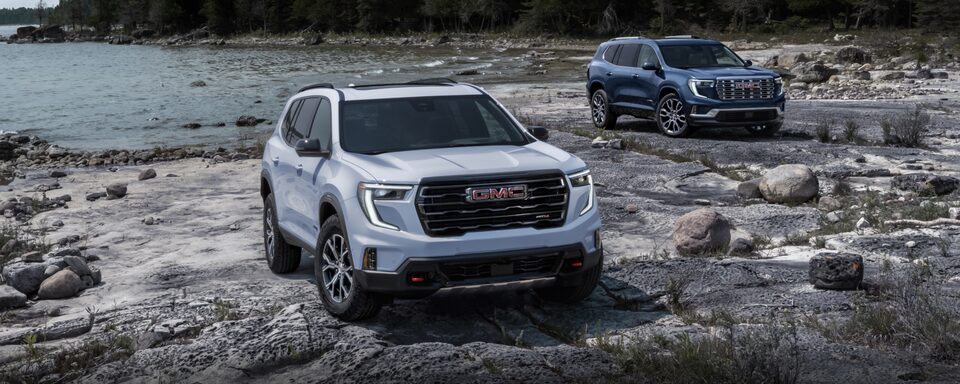 Two 2024 GMC Acadia's Parked Off-Road on Rocks Near the Water