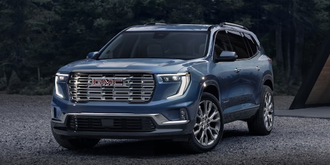  2024 blue gray GMC Acadia parked on gravel campgrounds