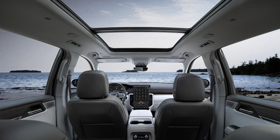 A Rear Passenger's View of the Interior of the 2024 GMC Acadia Denali with the Open Sunroof