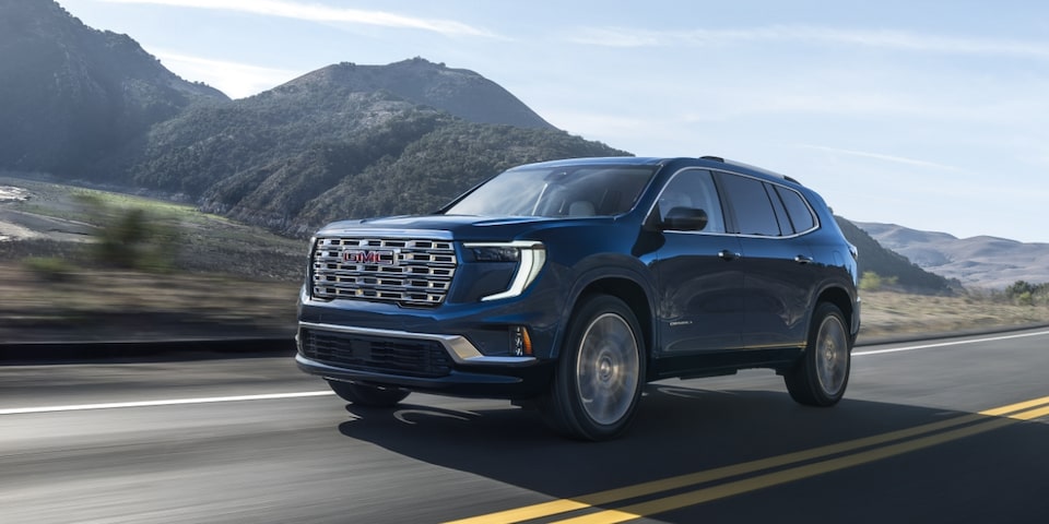 Wide Front Three-Quarters View of a 2024 GMC Acadia Denali Driving on a Highway