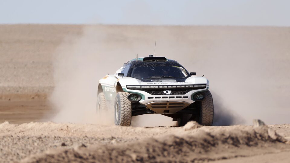 Front View of a Race Car Driving in a Desert Kicking up Dust