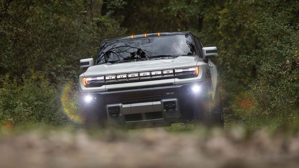 Alt Text: 2021 GMC HUMMER EV Electric Truck driving with fog lights on