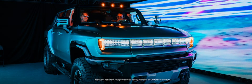 Two People Sitting in a GMC HUMMER EV inside a Showroom