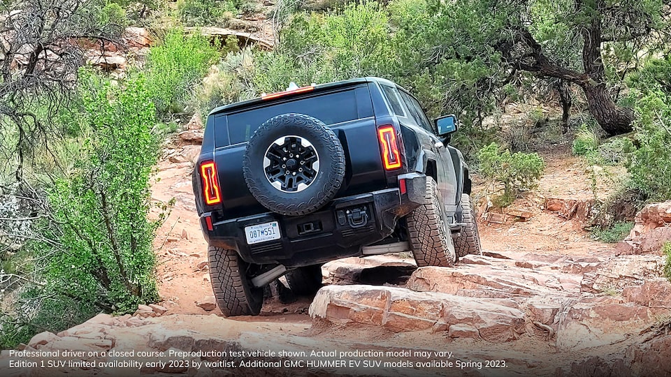 Rear View of the GMC HUMMER EV Driving Over Rocky Terrain