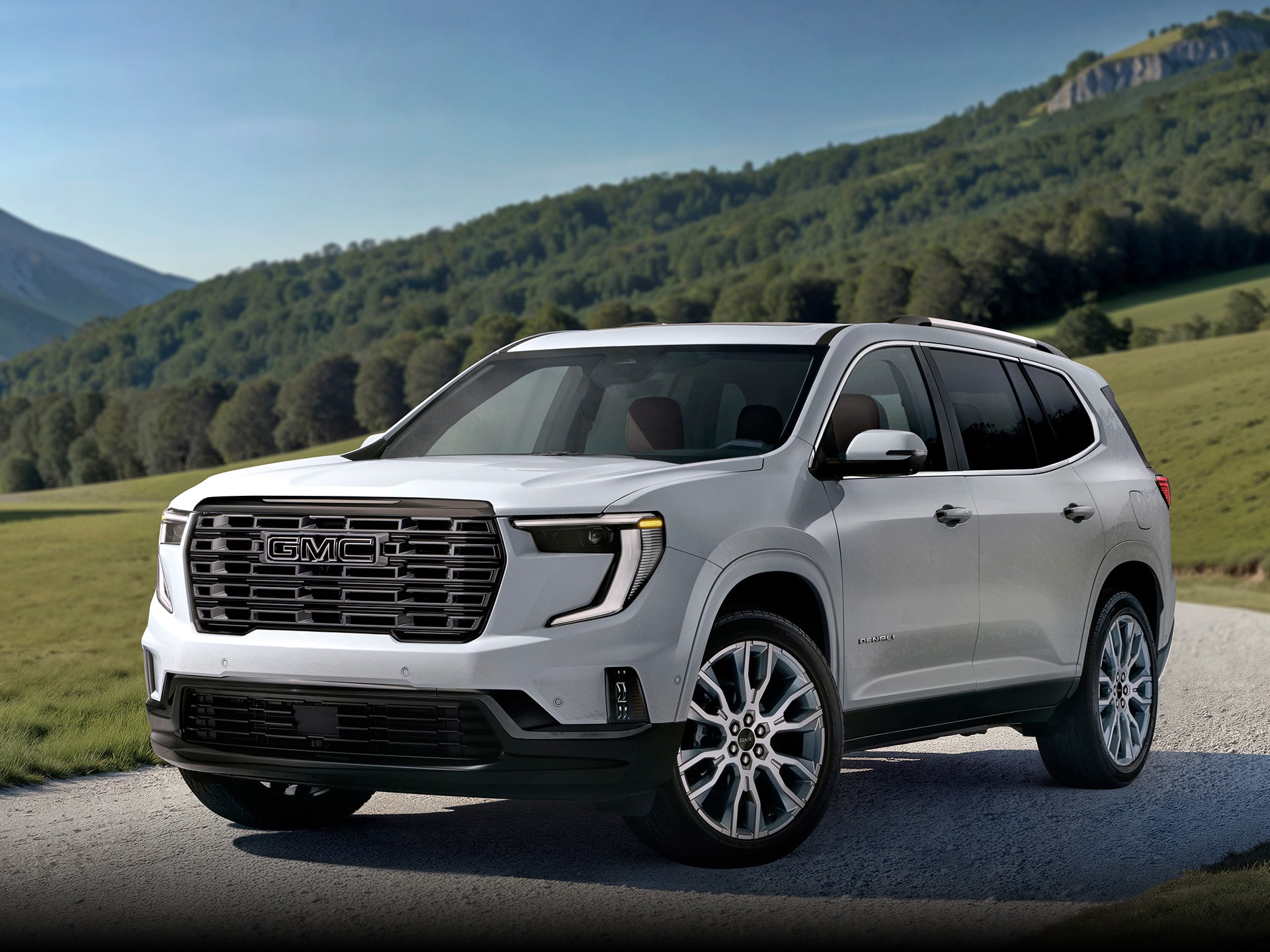 Front Three-Quarters Exterior View of the 2026 GMC Acadia Denali Ultimate Luxury Mid-Size SUV Parked in a Long Driveway