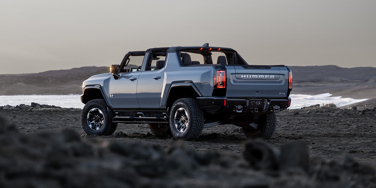 Rear Three-Quarters View of the 2026 GMC HUMMER EV Pickup Truck Parked Near a Body of Water
