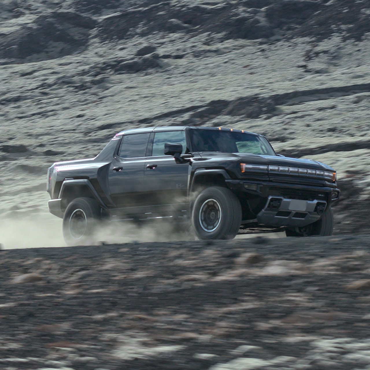 2026 gmc hummer ev driving on gravel on dirt road