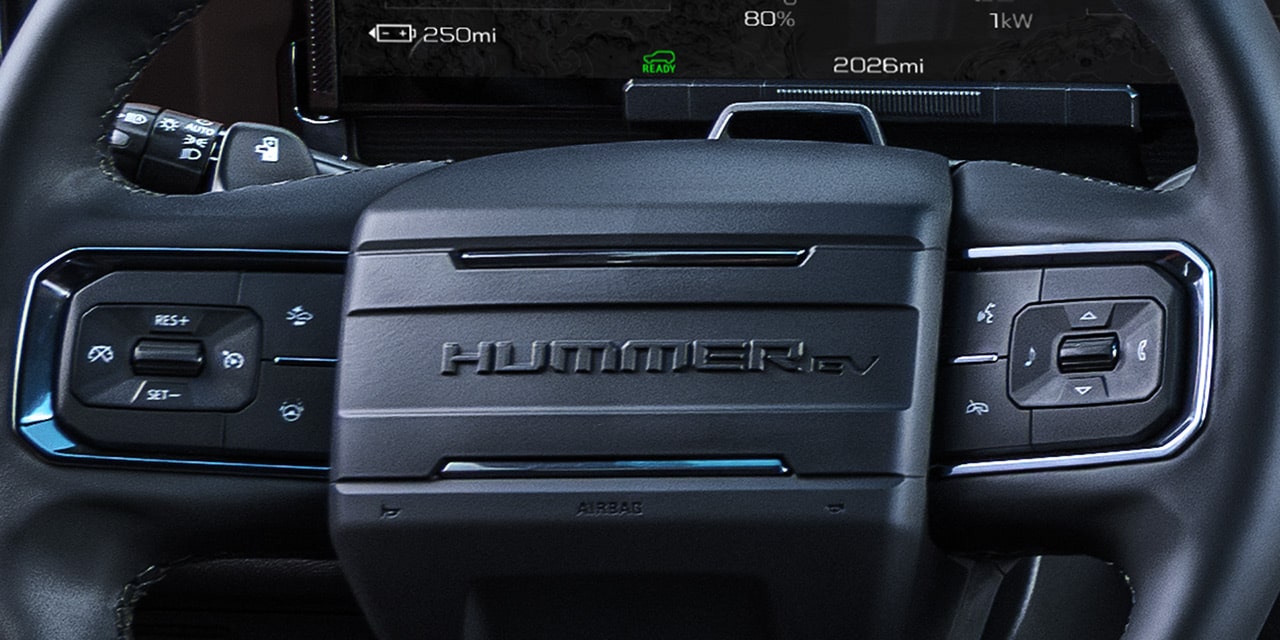 Close-up of the HUMMER EV Logo on the Steering Wheel with the Dashboard Displaying Regen on Demand
