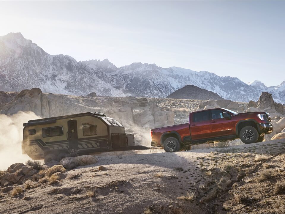 The New GMC Sierra HD AT4X Driving Uphill Off-road Towing a Trailer
