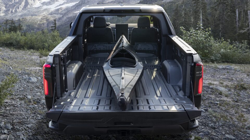 Closeup on the open Trunk of the GMC Sierra EV with Text Overlay saying "Available GMC Multiprop Midgate