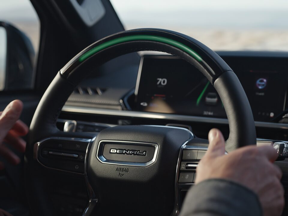 A Person with their hands on the Wheel of the new GMC Sierra EV Denali