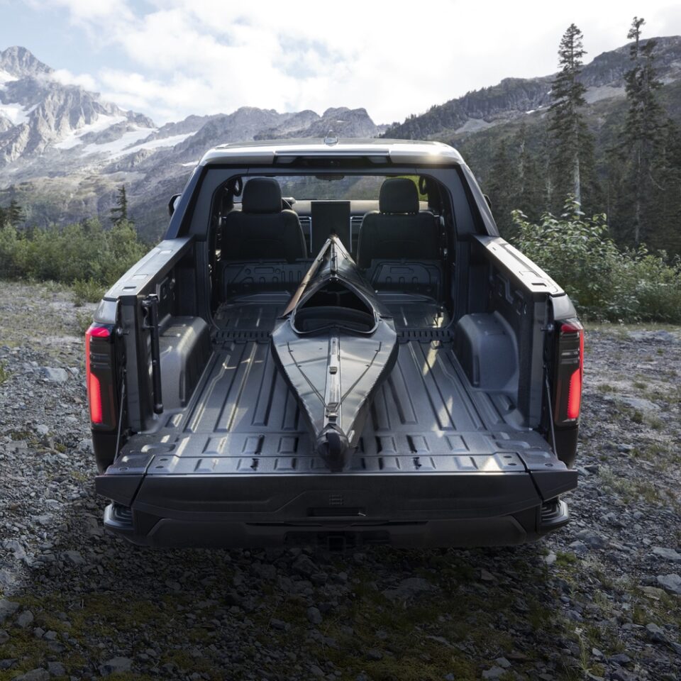 The Rear Trunk Open with a Canoe in it on the GMC Sierra EV Denali Parked Off-Road