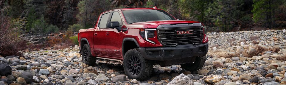The All Red GMC Sierra LD Driving Off-Road on Rocks