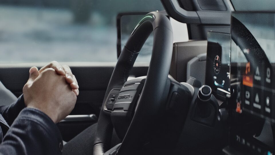 A Hummer EV Owner Relaxes Hands-Free while Using the Super Cruise Feature 
