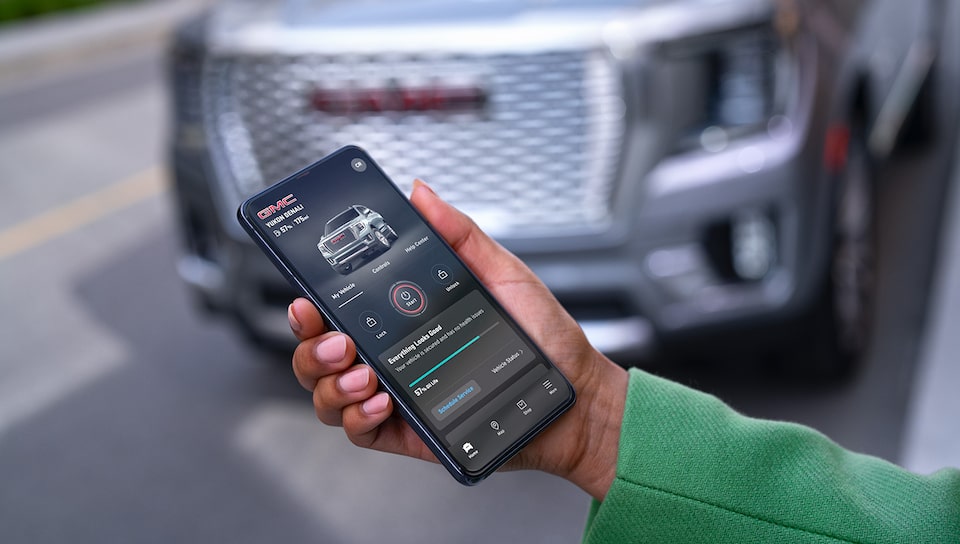 A Hummer EV Owner Using the myGMC Mobile App to Adjust Settings