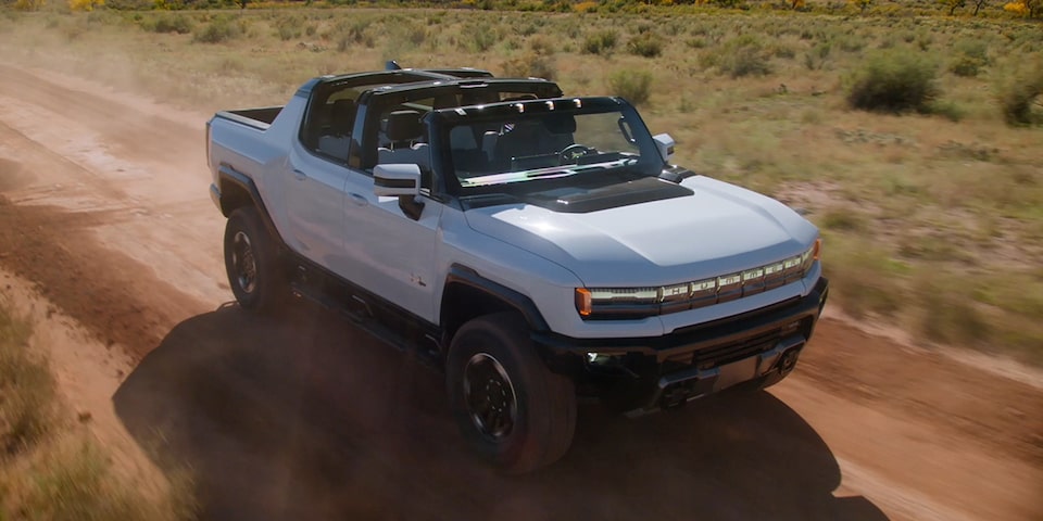 The Hummer EV Pickup Speeding Through the Desert with the Infinity Roof Open 