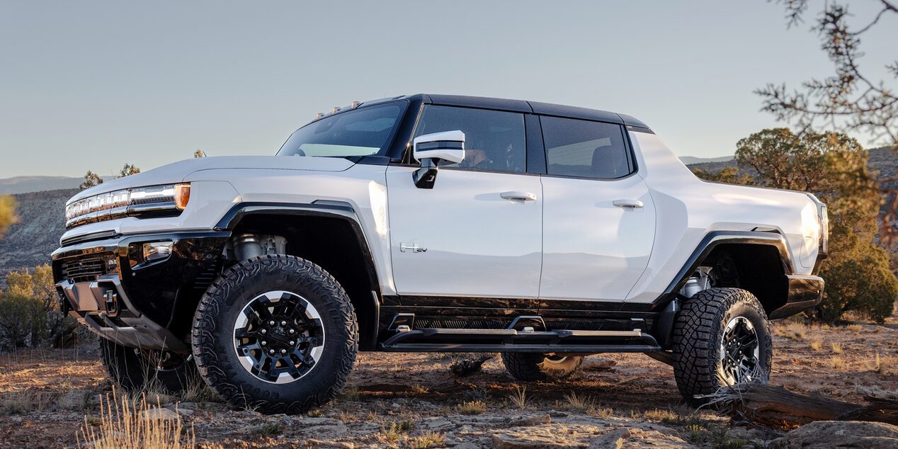 2024 GMC white Hummer EV pickup rock climbing in the desert