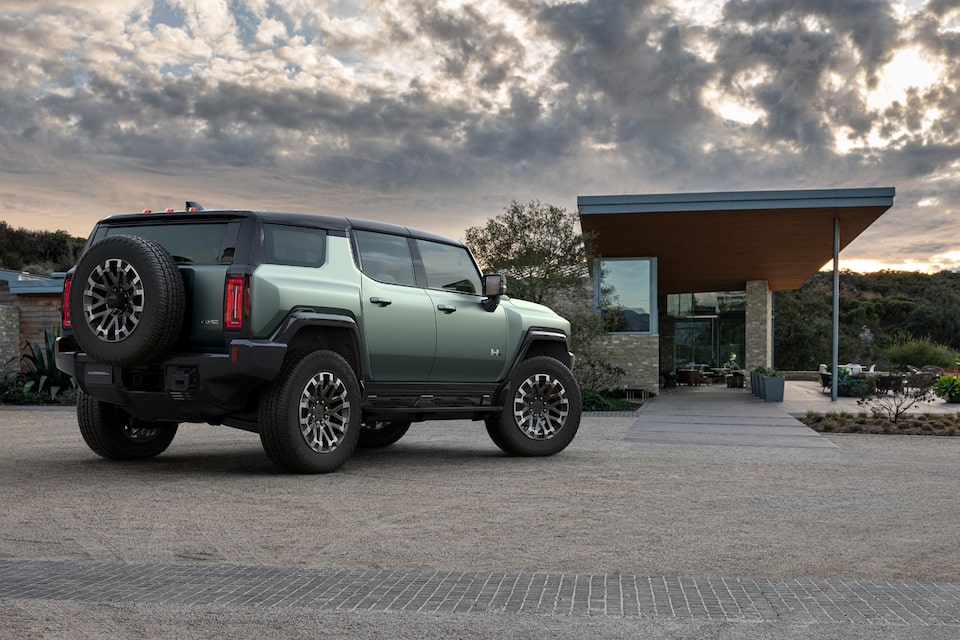 The Hummer EV SUV Parked in front of a Luxurious Home During a Cloudy Day