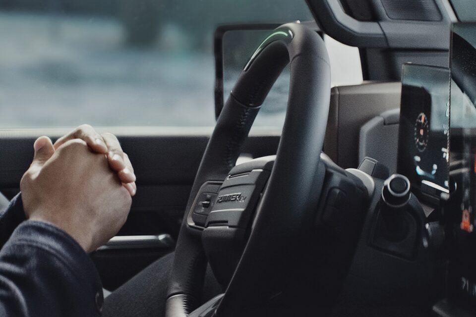 A Hummer EV SUV Owner Relaxes Hands-Free while Using the Super Cruise Feature 
