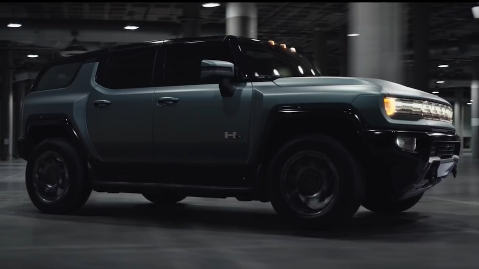 The Imposing Front End of the Hummer EV SUV on Display while Driving on an Open Road