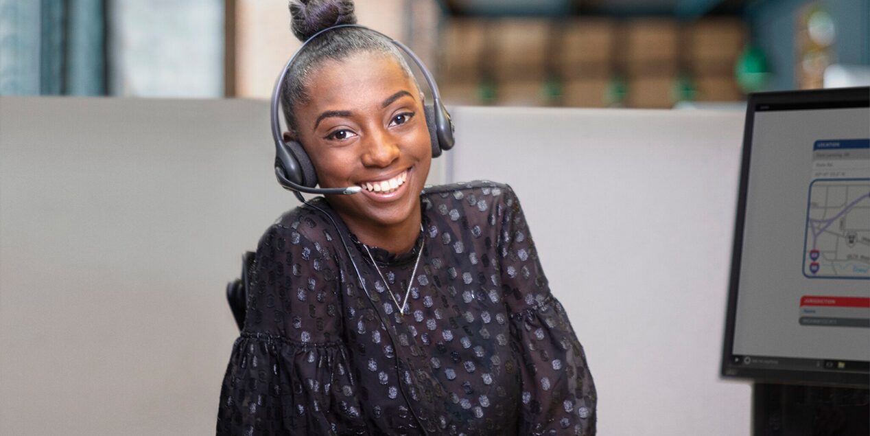 An OnStar Advisor Smiling at the Camera with a Headset on