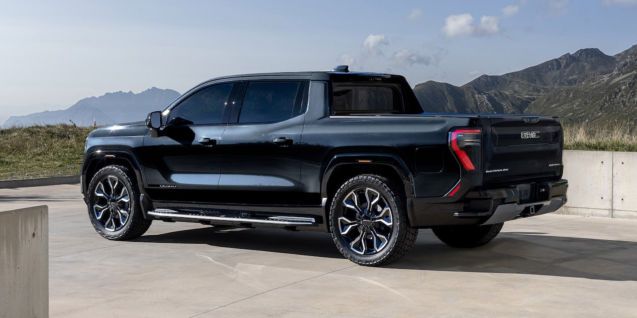Rear Three-Quarter View of the GMC Sierra EV Parked in a Driveway on a Sunny Day