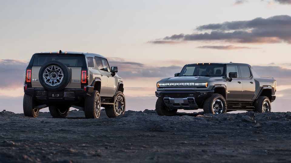 The GMC HUMMER EV SUV and The HUMMER EV Pickup Truck Parked Off-Road as the Sunsets
