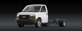 A White GMC Savana Cutaway Van Chassis with An Exposed Rear Frame Against a Dark Background