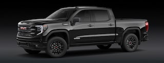 An Onyx Black GMC Sierra 1500 Elevation Pickup Truck Is Parked From a Front Three-Quarters Angle Against a Dark Background