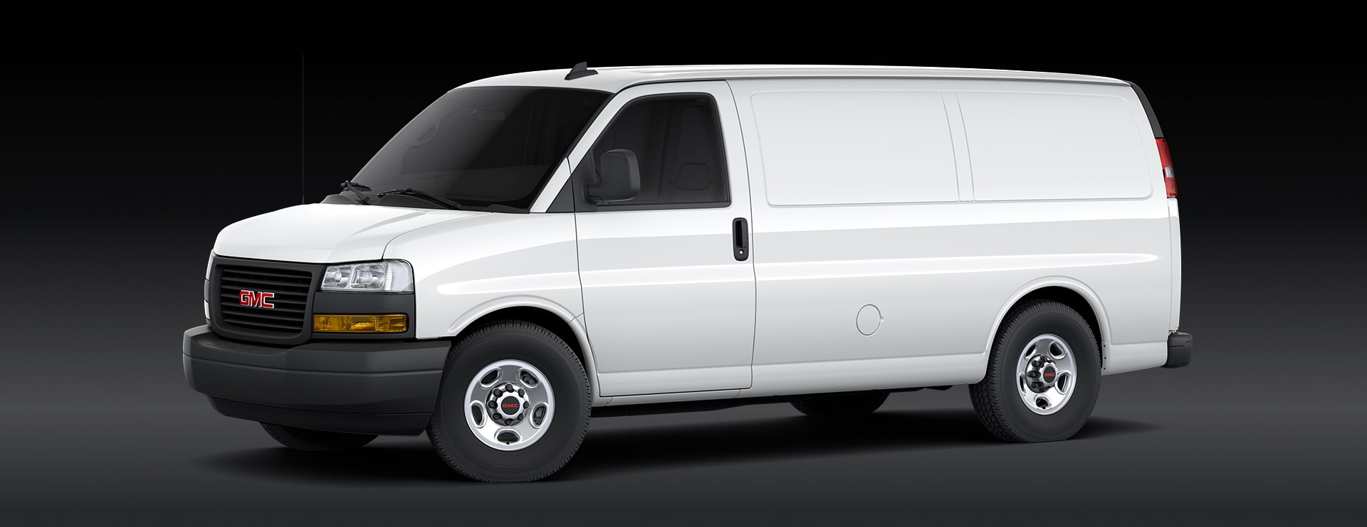 A White GMC Savana Cargo Van Is Parked From a Front Three-Quarters Angle On a Dark Background