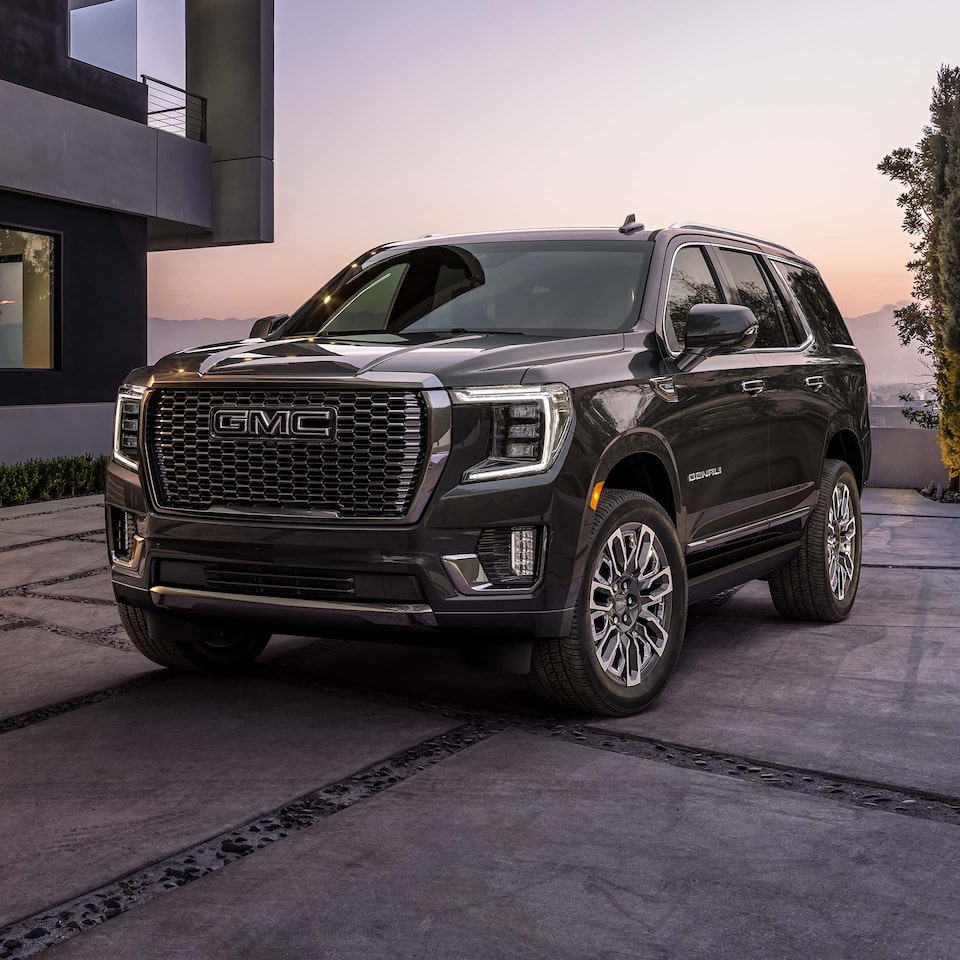2024 GMC Yukon Denali Parked by a Home With a Sunset in the Background