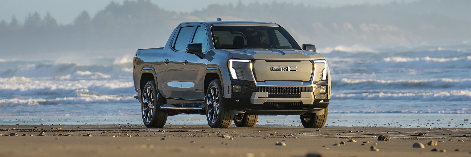 2025 GMC Sierra EV driving on beach
